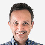 A man in a floral shirt smiles for the camera.