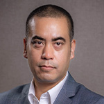 A man in a suit and tie is posing for a photo.