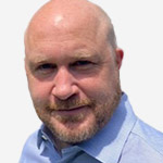 A bald man wearing a blue shirt.