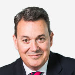 A man in a suit and tie poses for a photo.