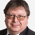 A man in a suit and tie is smiling.