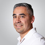 A man in a white shirt smiling for the camera.