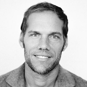 A black and white photo of a man smiling.