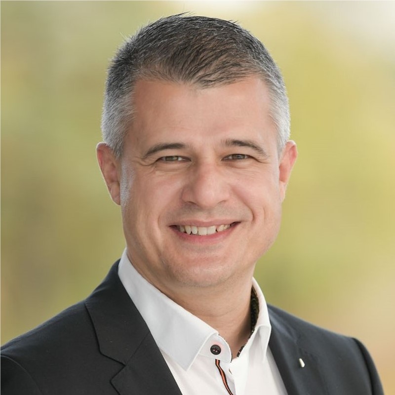 A man in a suit smiling for the camera.